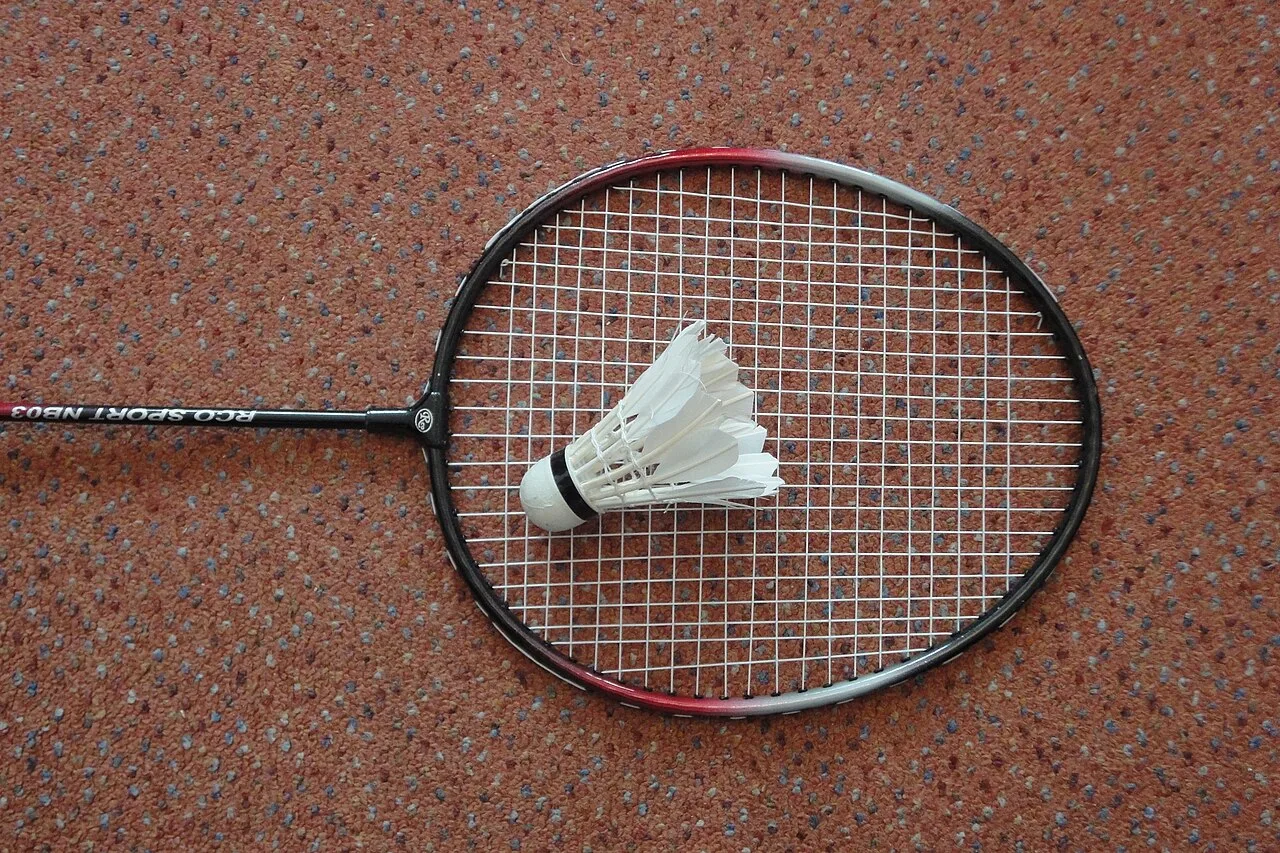 Raquette de badminton et volant posés au sol