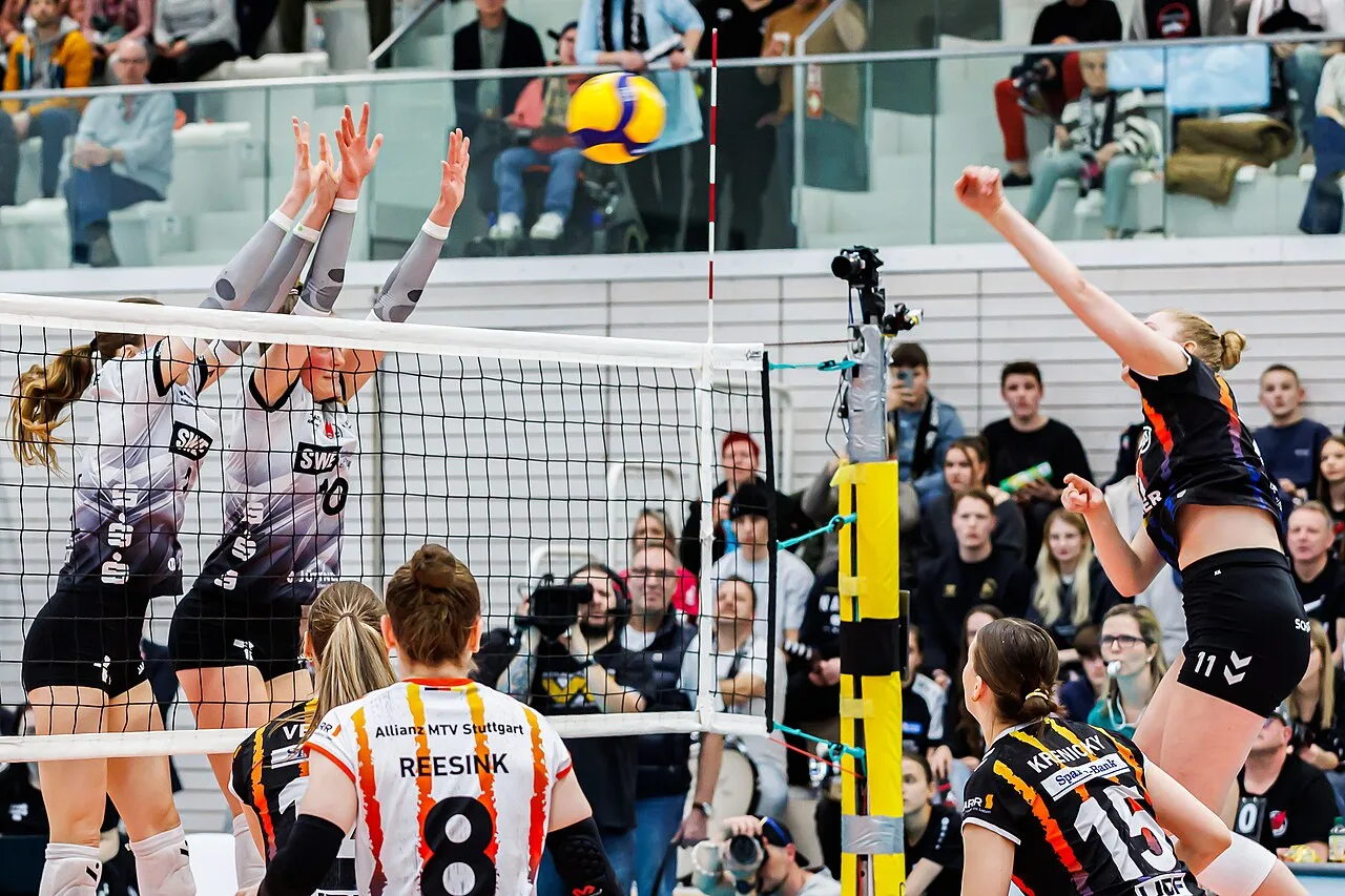 Volleybalsters spelen een punt aan het net in een sporthal